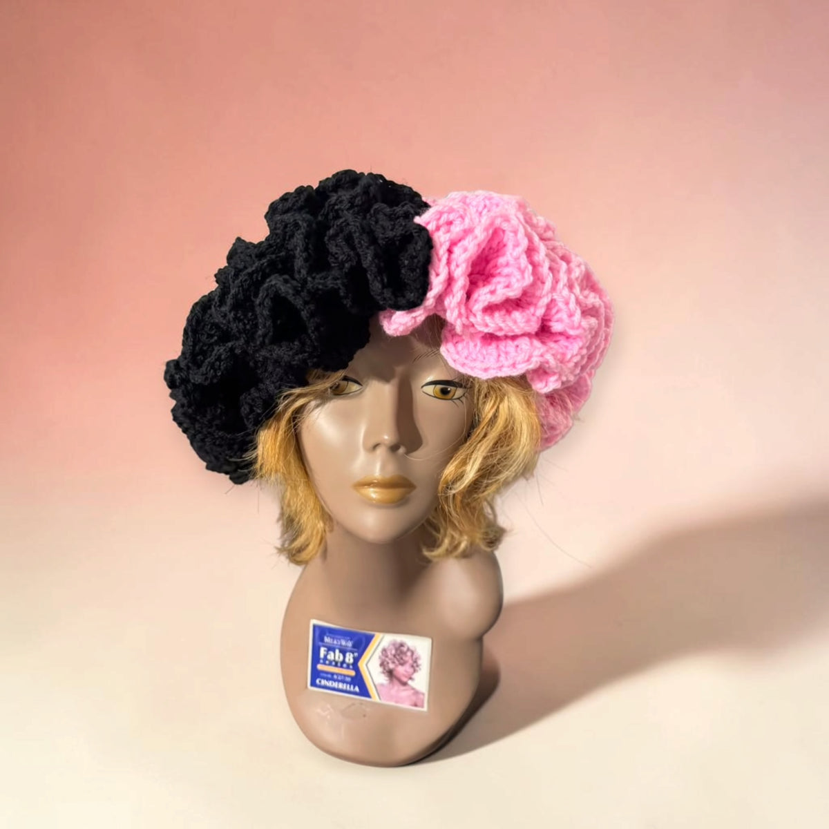 Voluminous two-tone crochet beret, half black and half bubblegum pink, with a deeply ruffled texture.