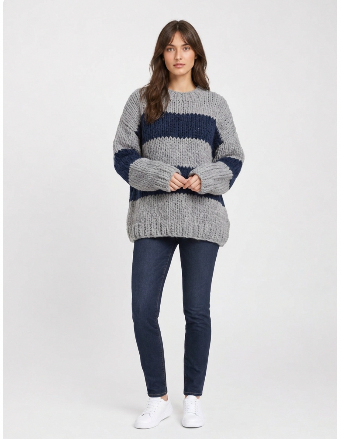 Oversized chunky knit crew-neck sweater in wide grey and navy stripes, worn with dark jeans.
