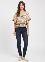 Boxy short-sleeve crochet top in cream with rust and tan open-weave stripes, worn with dark jeans.
