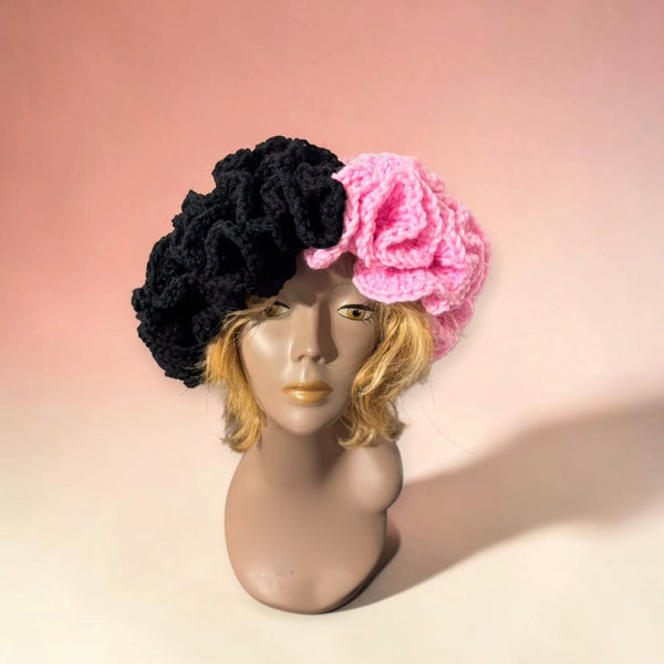 Voluminous two-tone crochet beret, half black and half bubblegum pink, with a deeply ruffled texture.
